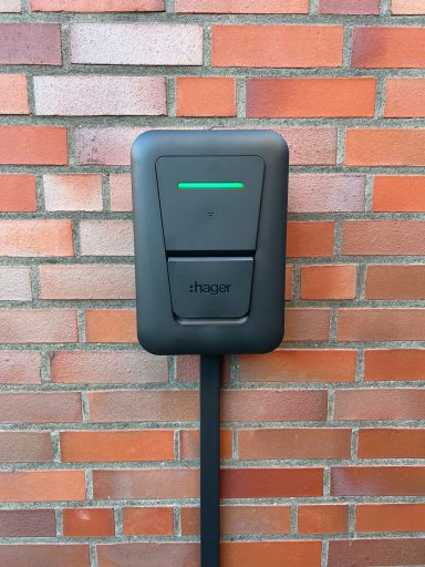 Wallbox-Installation Schwarze Ladestation für Elektroautos an einer Ziegelwand installiert.