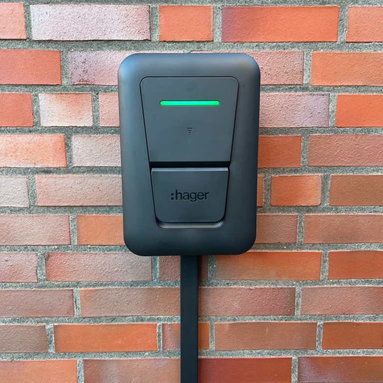 Wallbox Ladegerät für Elektrofahrzeuge an einer roten Ziegelfassade.